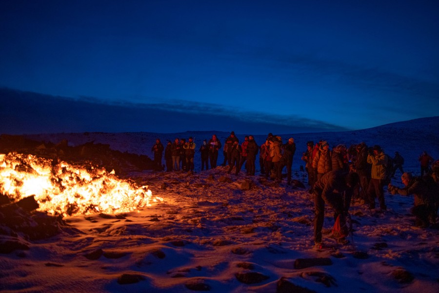People watch lava flow in Iceland.
