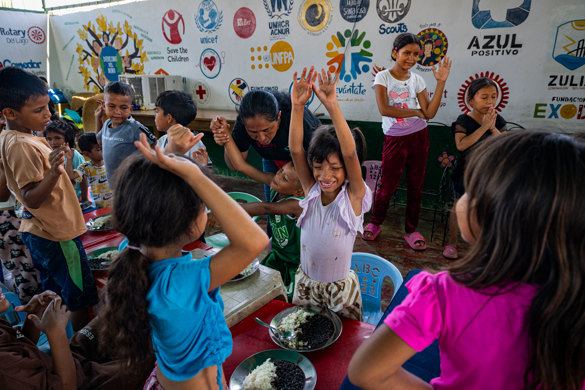 a large group of children eats lunch at a community kitchen