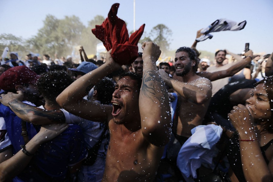 A crowd of soccer fans cheer and celebrate.