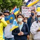 Taiwanese hold up Ukrainian flags at a rally.