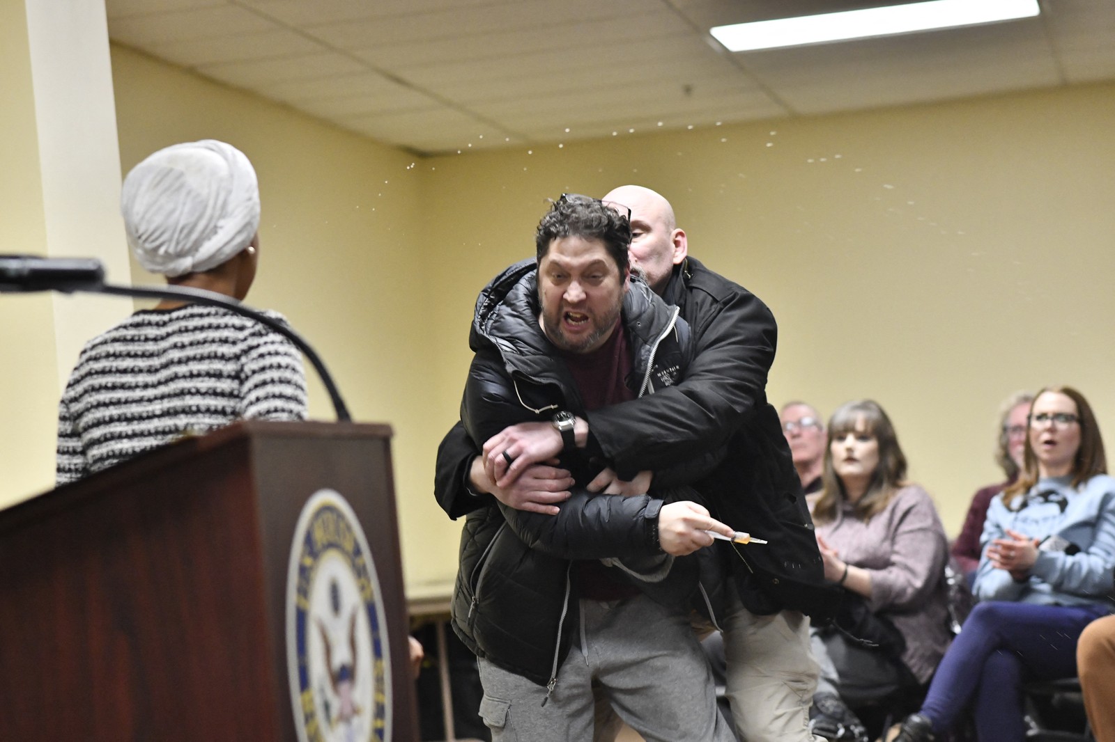 A man is tackled after spraying an unknown substance at U.S. Representative Ilhan Omar.