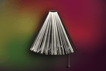 A book in the shape of a lampshade with a lamp cord hanging from the bottom.