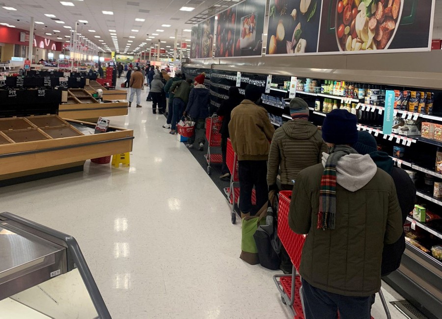 People stand in a long line inside a Target store.