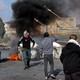 Palestinians use slingshots to throw stones toward Israeli soldiers during a demonstration in Ramallah, the West Bank, on October 18, 2023.