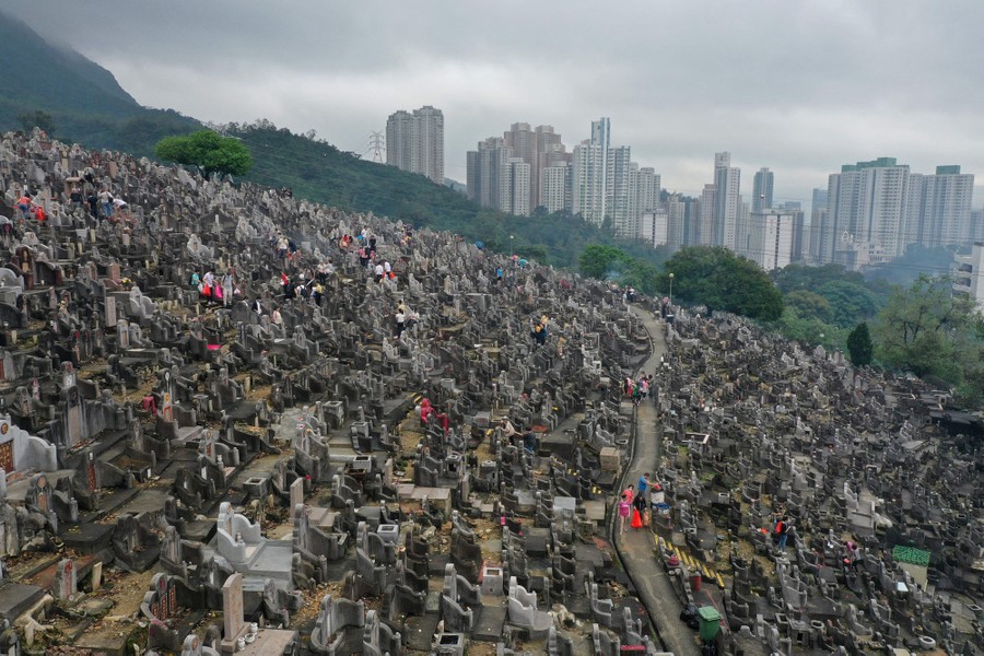 People visit a steep hillside cemetery in Hong Kong.