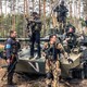 Ukrainian soldiers and foreign fighters gathered around a tank during a military operation