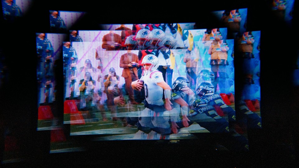 Photo of multiple blurry screens showing the Super Bowl