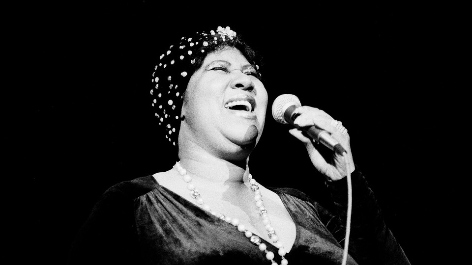 A black and white photo of Aretha Franklin singing