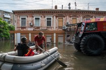 Rescue workers paddle a boat through flooded streets in Kherson.