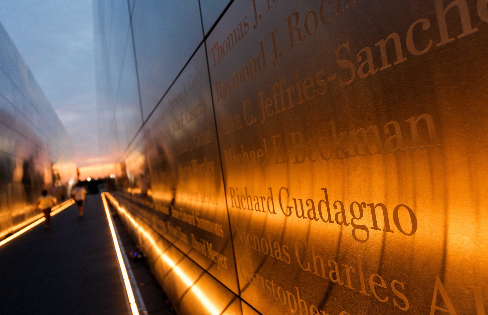 Names inscribed on a memorial, lit warmly.