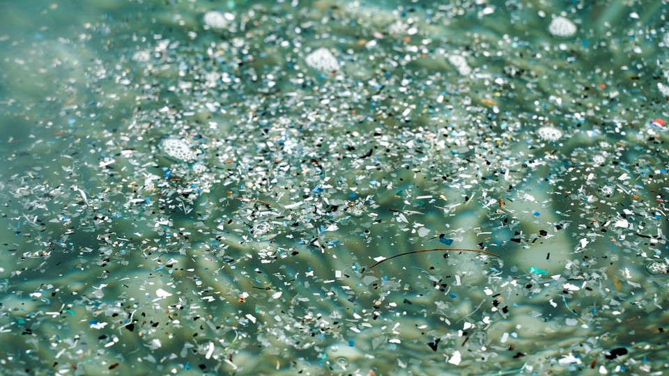Plastic and debris floating in greenish water