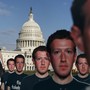 Cardboard cutouts of Mark Zuckerberg's face dominate the foreground, while the dome of the U.S. Capitol looms in the background.