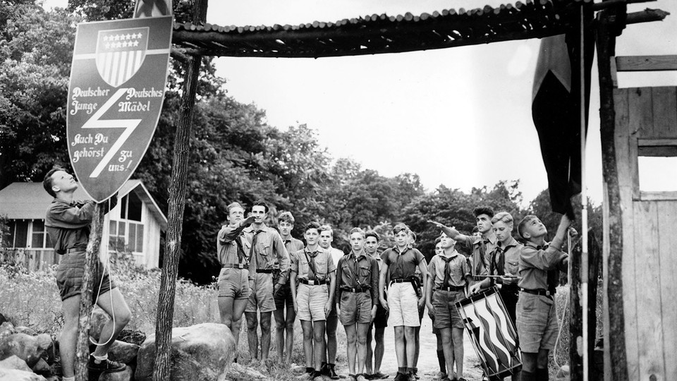 Nazi youths in uniform salute at the entrance to a German American Bund camp