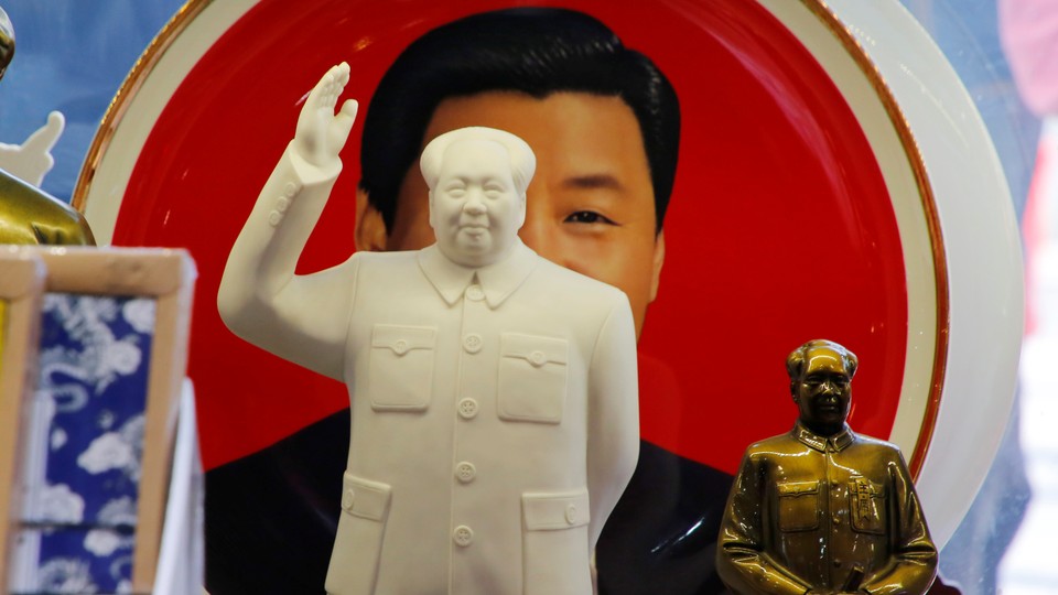 Sculptures of the late Chinese Chairman Mao Zedong in front of a souvenir plate featuring a portrait of Chinese President Xi Jinping at a shop next to Tiananmen Square in Beijing, China, on March 1, 2018.