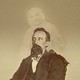 A vintage photo of a bearded man with the ghostly image of another person superimposed