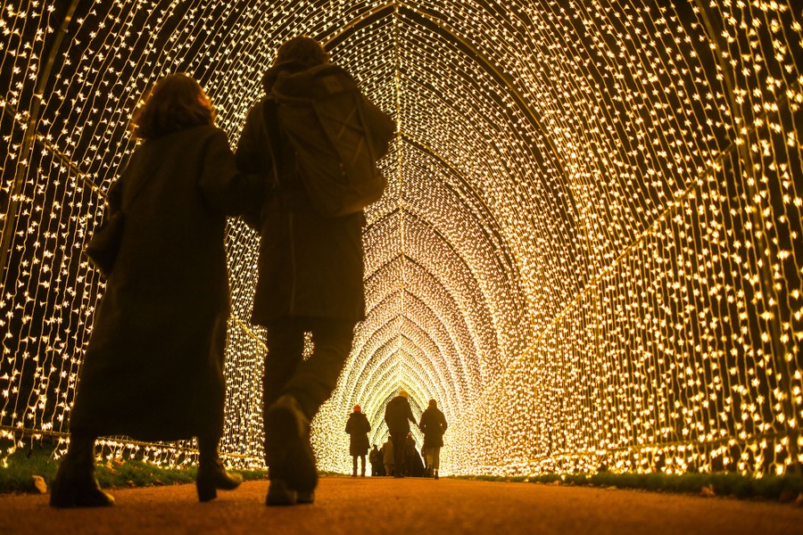 People walk through a tunnel of lights.