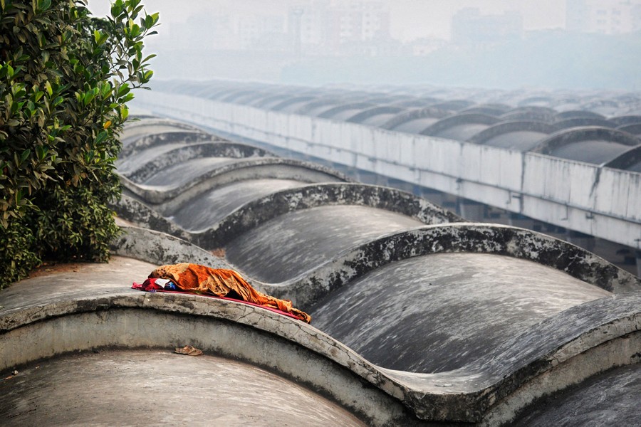 A person lies on the roof of a building.
