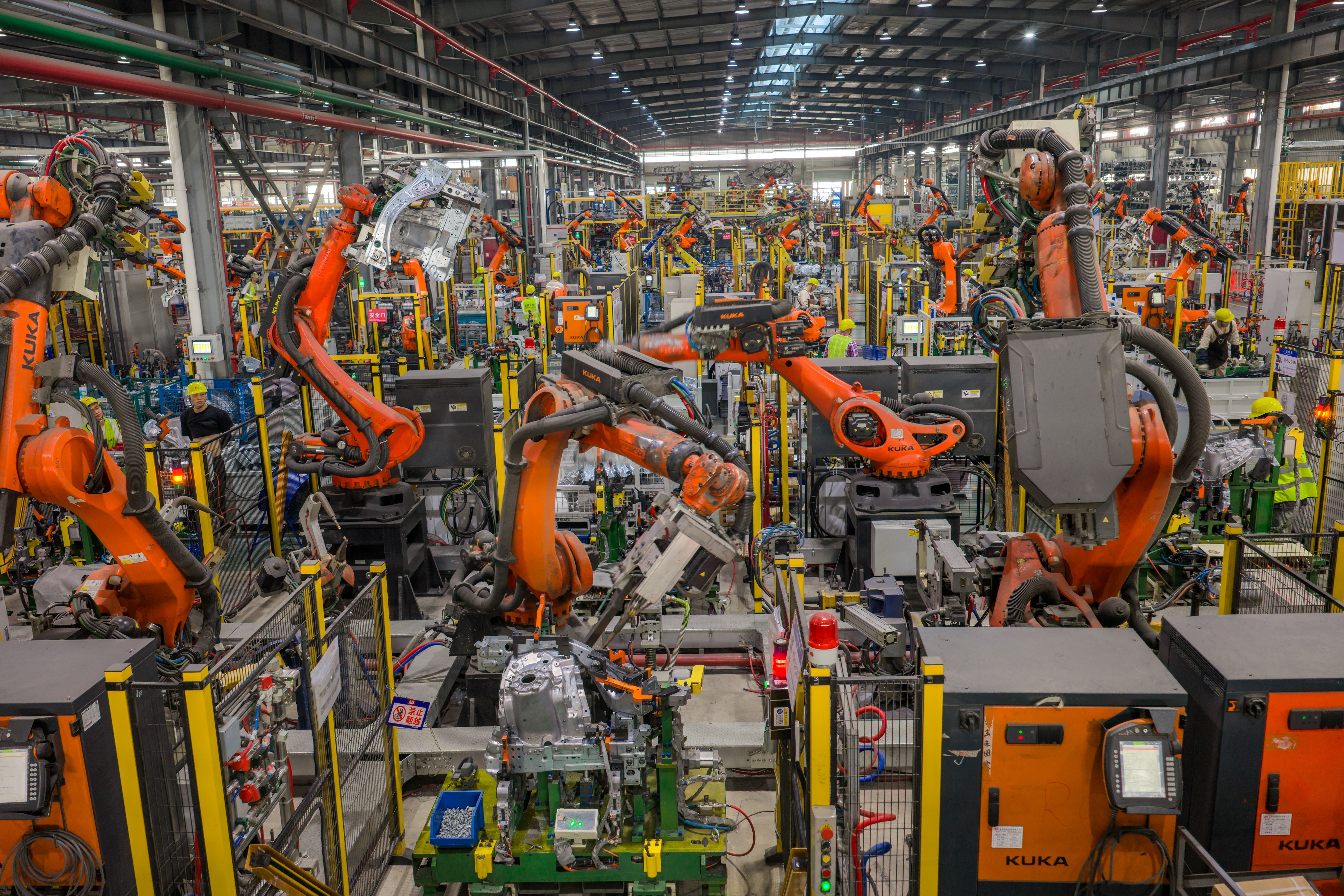 Many industrial robots work on a production line in a factory.