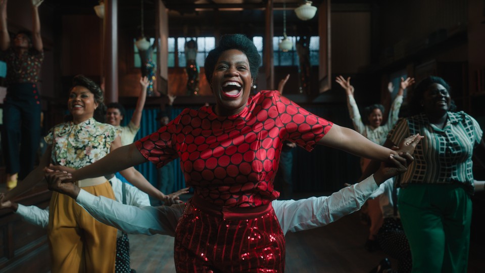 Fantasia Barrino wearing a red dress and red lipstick in "The Color Purple"