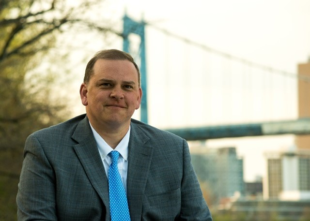 Mayor Wade Kapszukiewicz, with a bridge behind him