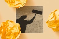 A black-and-white photo shows the shadow of a person holding up a protest sign.