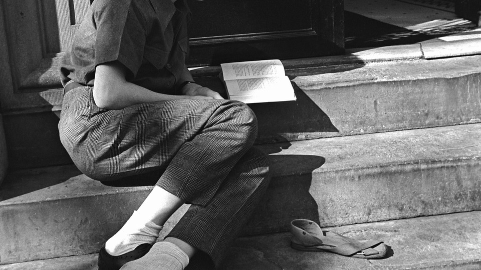 A photograph of a person reading on stairs