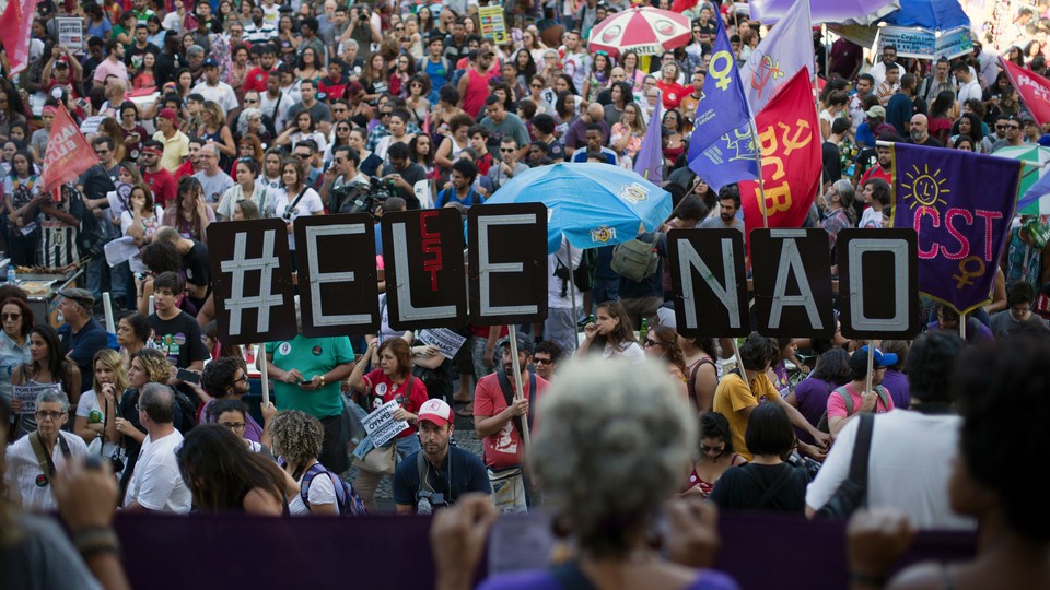 Demonstrators protest in Rio de Janeiro days before Bolsonaro was elected. They told a large sign saying "#EleNao," or "#NotHim."