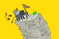 man sitting in an office desk on top of a stack of papers