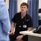 A red-headed man in a doctor's outfit looks concerned.