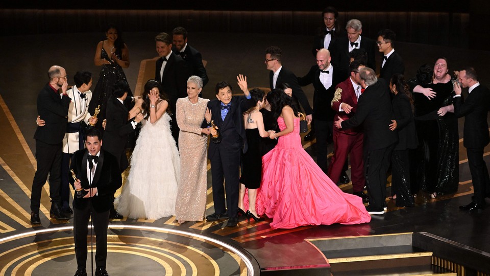 Jonathan Wang accepting the Best Picture Oscar for "Everything Everywhere All at Once," with the rest of the cast and crew behind him