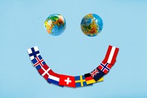 An illustration of a smiley face, with two globes as the eyes and a spread of countries' flags as the mouth