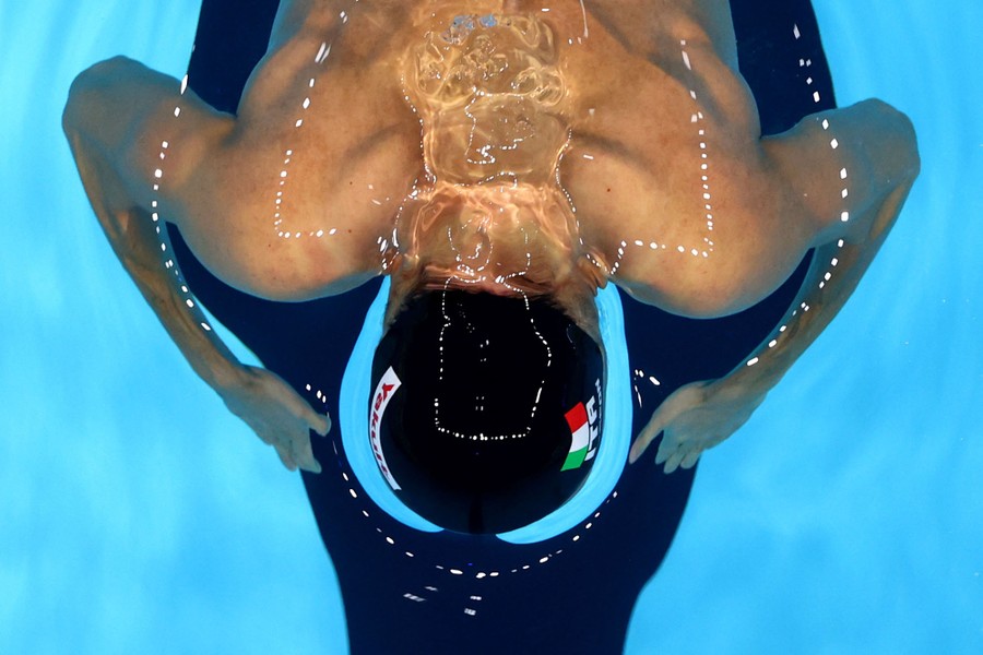 Water flows over a swimmer's head, distorting the view of the swimmer.