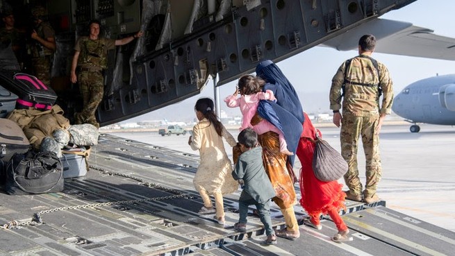 A family boards a military airplane
