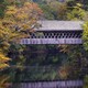 A covered bridge is flanked by autumn leaves beginning to change color along the Contoocook River in Henniker, New Hampshire, on October 6, 2023.