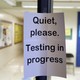 A sign asking people to be quiet while testing takes place
