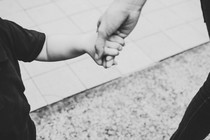 A parent and child holding hands