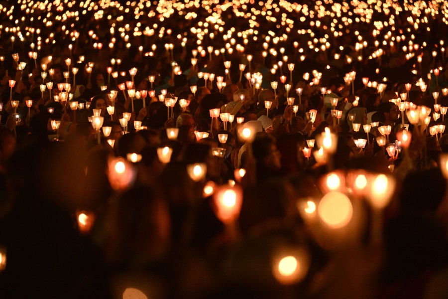 A large crowd of people holding lit candles