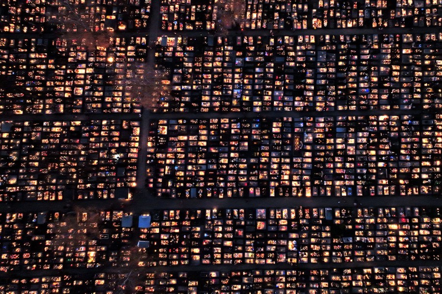 An aerial photograph showing a cemetery illuminated with candles
