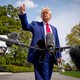 Donald Trump holds a thumbs up in front of boom mics