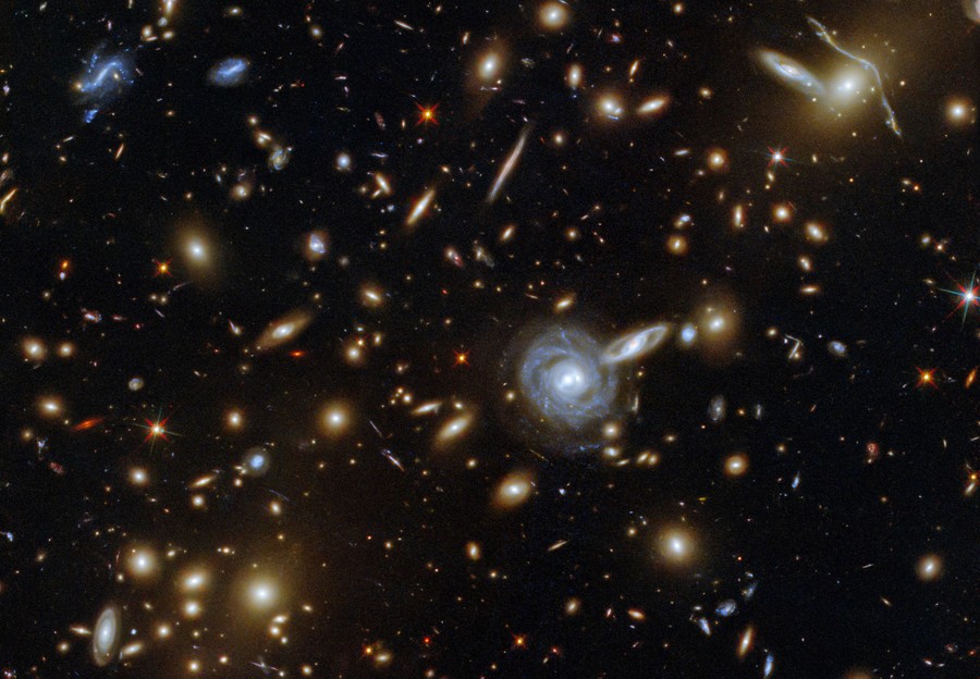 Dozens of galaxies and stars are seen crowded together.