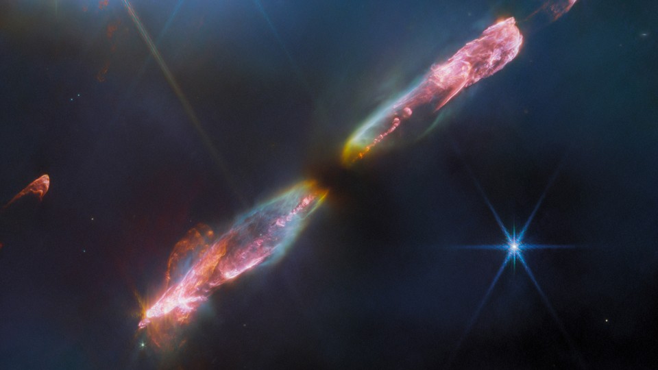 An image from the James Webb Space Telescope of a protostar spewing two jets of luminous cosmic material