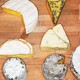 variety of cheese on a wooden board