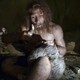 A museum exhibit shows a right-handed Neanderthal man working with a tool.