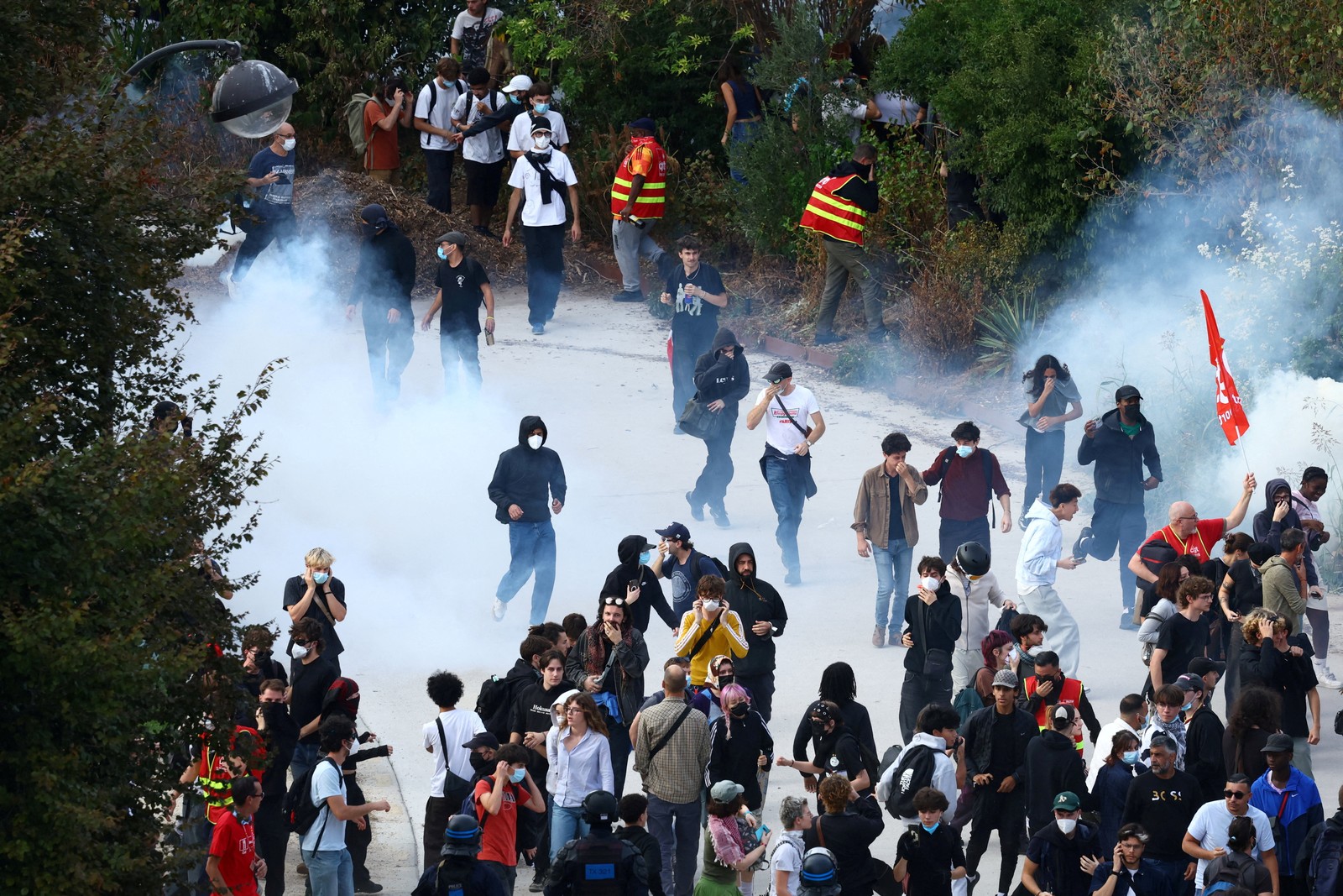 Protesters walk away from a cloud of tear gas.
