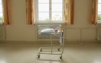 a baby in a hospital bassinet in a room
