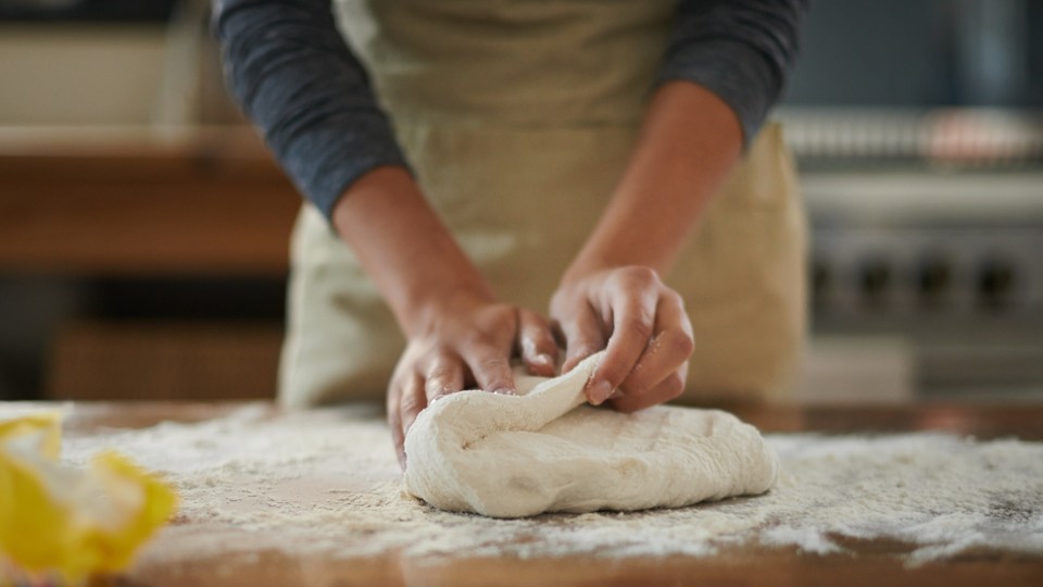 A woman kneads bread