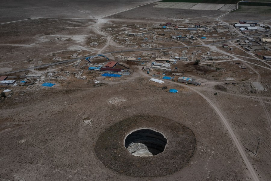 A large, deep hole sits just outside a small village.