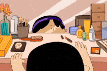 A moving image of a small child reaching for lipstick in front of a mirror