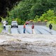 Onlookers inspect a flooded road in Southern Vermont