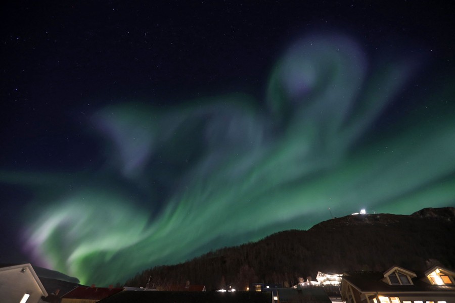 Swirling lights appear in the night sky above a northern town.